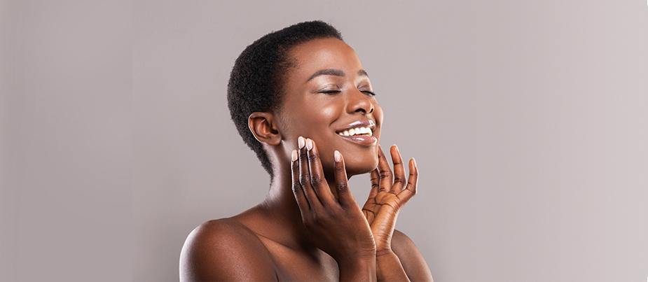 young black teen holding her face while smiling in a side view