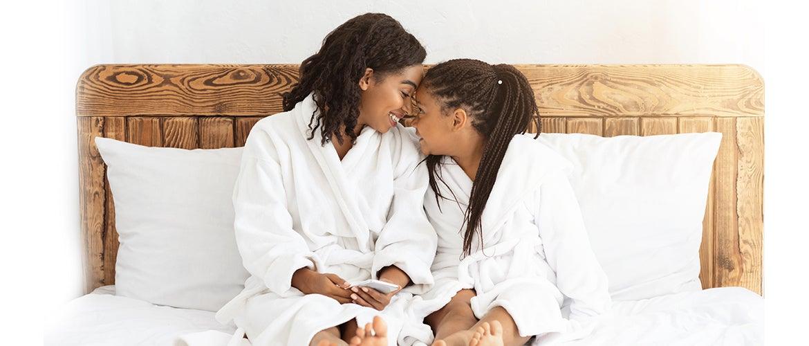 mother and daughter sitting at the bed 