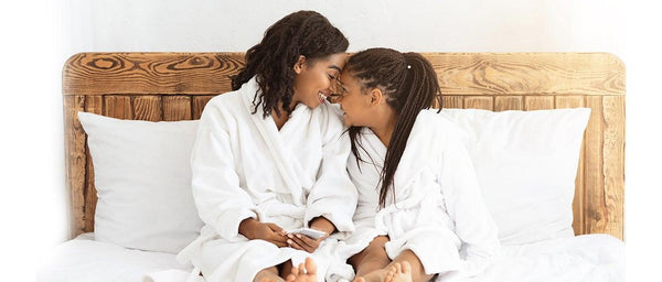 mother and daughter sitting at the bed 